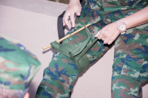 Improvised above the knee tourniquet on soldier in camouflage gear