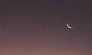 a small crescent moon in a starry night sky